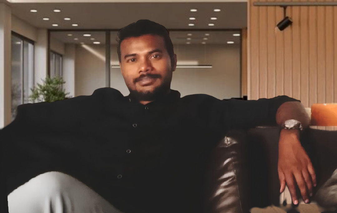 A professional man sits comfortably in a modern office space, promoting a welcoming work environment.