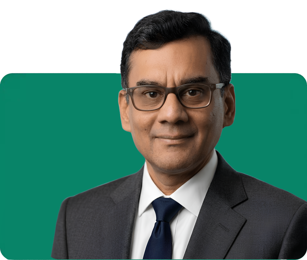 Professional headshot of Vinay Peshwa, managing partner and startup advisor, smiling in a suit and tie on a green background